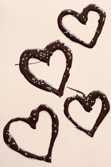 Chocolate hearts and confetti on light background - HSTF00059