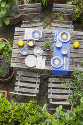Gartentisch mit bunten Tellern und Schalen gedeckt - GWF05464