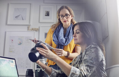 Fotografinnen mit Digitalkamera und digitalem Tablet im Büro - CAIF07087