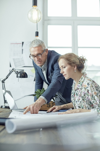 Architekten, die im Büro Blaupausen besprechen und überprüfen, lizenzfreies Stockfoto