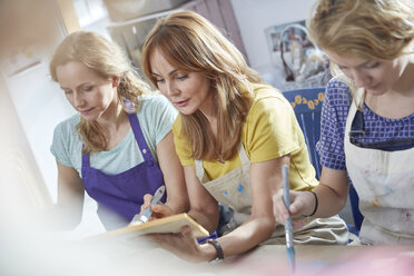 Künstlerinnen malen Bilderrahmen in einem Workshop der Kunstklasse - CAIF07160