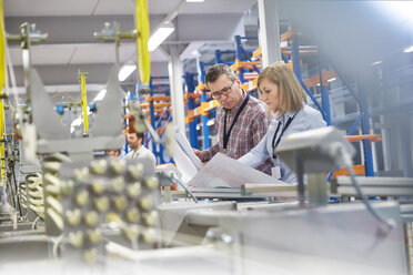 Vorgesetzter und Ingenieur besprechen Pläne in einer Glasfaserfabrik - CAIF07189