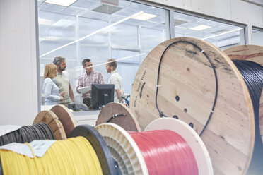 Vorgesetzte sprechen im Büro hinter Spulen in einer Glasfaserfabrik - CAIF07198