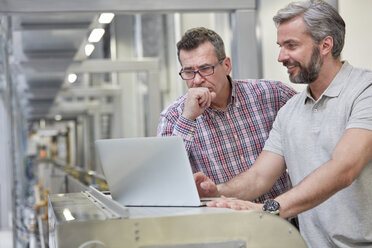 Männliche Vorgesetzte benutzen Laptop in der Fabrik - CAIF07214