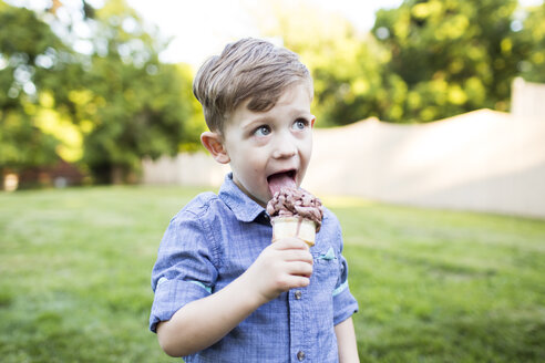 Junge im Vorschulalter isst Eiswaffel im Sommergarten - CAIF07233