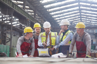 Männlicher Vorarbeiter, Ingenieure und Arbeiter treffen sich in einer Fabrik - CAIF07260