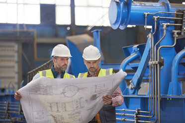 Ingenieure bei der Überprüfung von Plänen in der Fabrik - CAIF07275