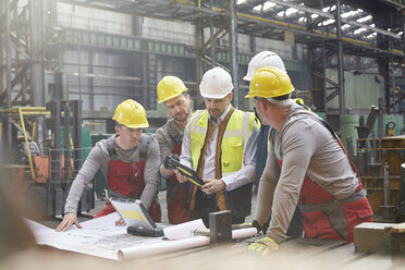 Männlicher Vorarbeiter, Ingenieure und Arbeiter mit digitalem Tablet bei einer Besprechung in einer Fabrik - CAIF07290