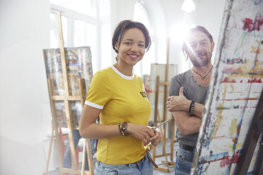 Porträt lächelnd Künstler malen an der Staffelei in Kunst Klasse Studio - CAIF07301