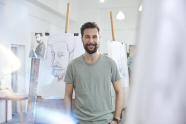 Portrait smiling, confident male artist sketching in art class studio - CAIF07312