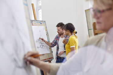 Künstler besprechen Skizze an der Staffelei im Atelier der Kunstklasse - CAIF07319