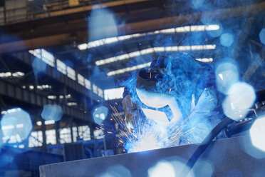 Welder in welding mask welding steel in factory - CAIF07330