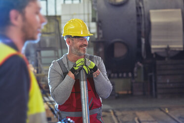 Lächelnder männlicher Ingenieur in einer Fabrik - CAIF07344