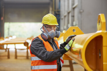 Male worker wearing protective mask in factory - CAIF07348