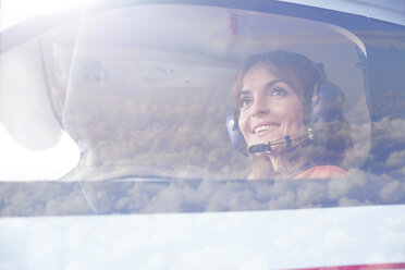 Lächelnde Pilotin im Cockpit eines Flugzeugs - CAIF07454