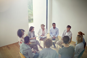 Menschen, die sich in einer Gruppentherapiesitzung im Kreis unterhalten - CAIF07485