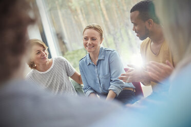 Menschen klatschen für eine Frau in einer Gruppentherapiesitzung - CAIF07488