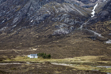 Haus in einem abgelegenen Tal unterhalb zerklüfteter Berge, Glencoe, Schottland - CAIF07523