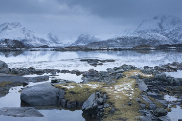 Schneebedeckte Berge hinter einer kalten, ruhigen Bucht, Lofoten, Norwegen - CAIF07530