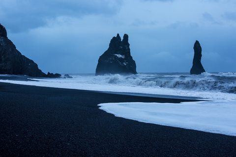 Felsformationen und stürmisches Meer in der Abenddämmerung, Reynisdrangar, Vik, Island, lizenzfreies Stockfoto