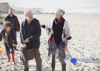 Mehrgenerationen-Familie beim Muschelschürfen am Strand - CAIF07553