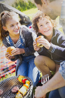 Vater und Kinder essen Hamburger am Grill - CAIF07565