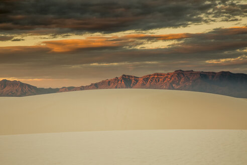 Dramatischer Sonnenuntergangshimmel über Sanddünen und Bergen, White Sands, New Mexico, Vereinigte Staaten - CAIF07592