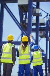 Worker and businessman examining cargo crane - CAIF07646