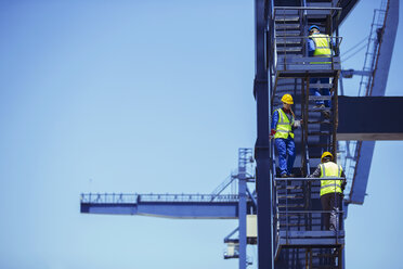 Arbeiter klettern auf einen Lastkran - CAIF07651
