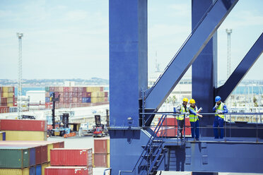 Business people and worker talking on cargo crane - CAIF07656