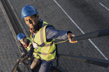 Workers standing on staircase - CAIF07668