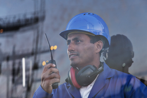 Arbeiter hält Walkie-Talkie am Fenster, lizenzfreies Stockfoto