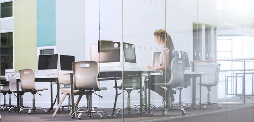 Teenage girl using computer in computer room - CAIF07675