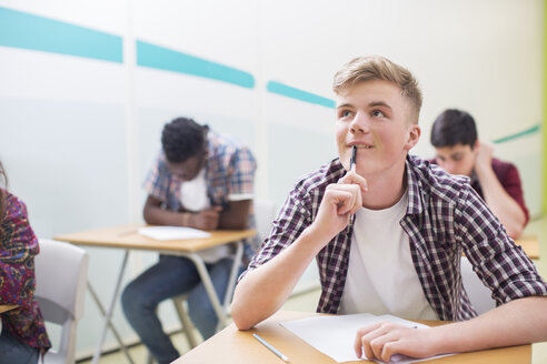 Nachdenklicher Schüler beim Schreiben seiner GCSE-Prüfung - CAIF07693