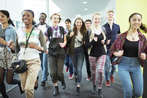 Gruppe fröhlicher Studenten, die im Korridor laufen - CAIF07710