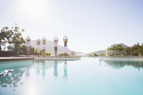Menschen üben Yoga am Pool, lizenzfreies Stockfoto