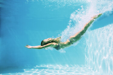 Woman diving into swimming pool - CAIF07760