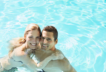 Portrait of smiling couple in swimming pool - CAIF07801