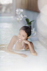 Woman smiling in hot tub at spa - CAIF07807