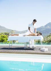 Frau erhält Massage am Pool - CAIF07809