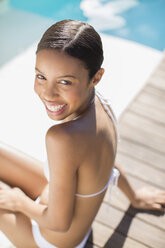 Portrait of smiling woman at poolside - CAIF07839