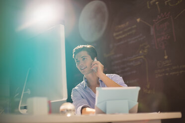 Businessman talking on telephone in office - CAIF07864