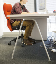 Geschäftsmann mit Computer am Schreibtisch im Büro - CAIF07867