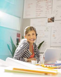 Geschäftsfrau mit Headset am Schreibtisch im Büro - CAIF07879