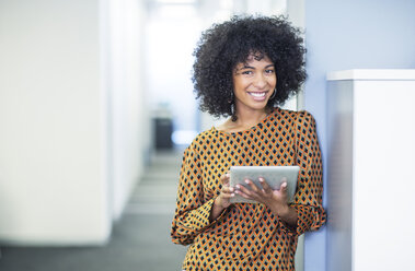 Porträt einer Frau, die ein digitales Tablet im Büro benutzt - CAIF07884