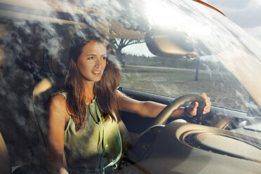 Woman looking away while driving car - CAVF01383