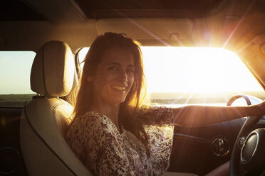 Portrait of happy woman sitting in car - CAVF01387