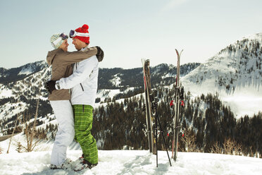 Seitenansicht eines Paares in Skikleidung auf einem schneebedeckten Berg - CAVF01398