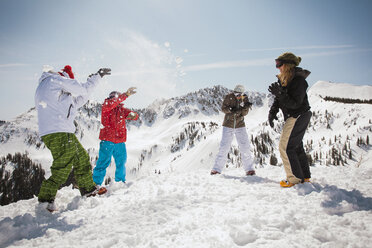 Glückliche Skifahrer, die auf einem schneebedeckten Feld mit Schnee spielen - CAVF01404