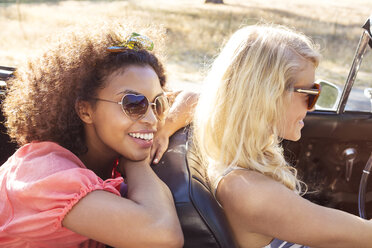 Happy friends sitting in car - CAVF01422